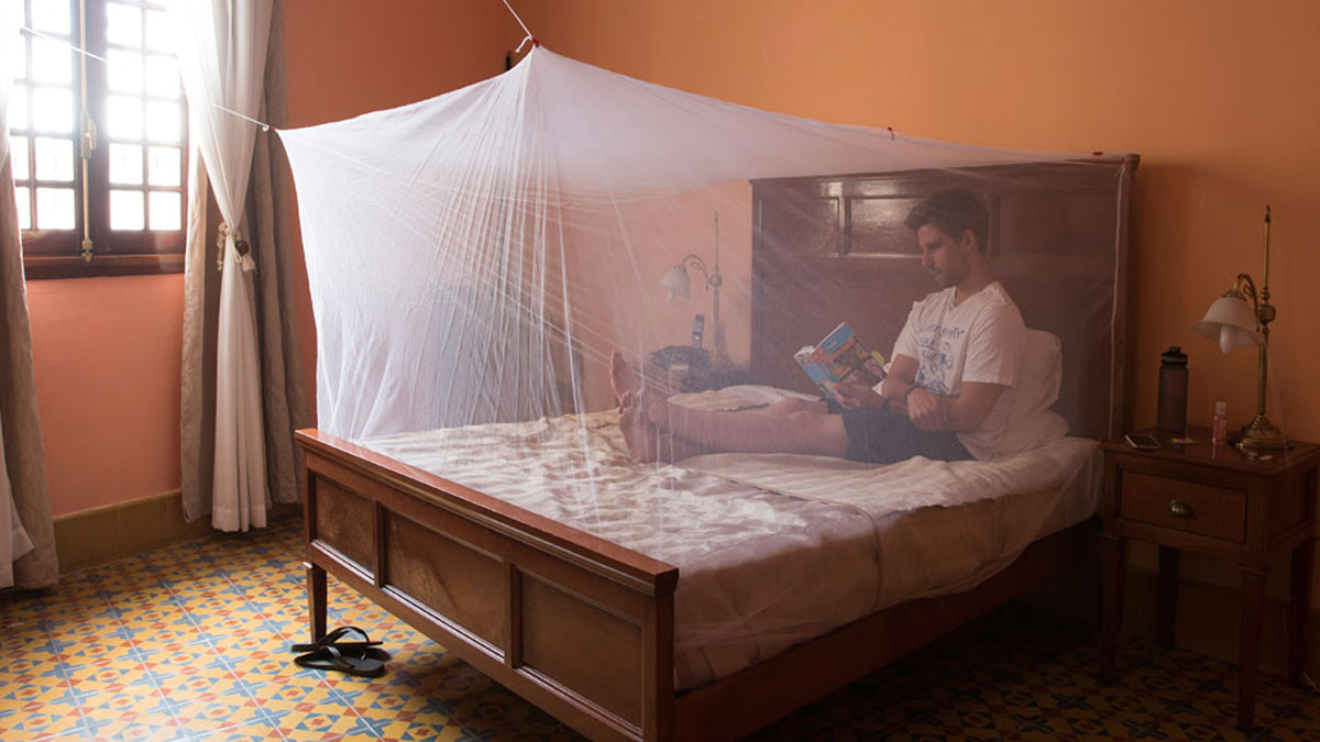 Box shaped mosquito net covering a abed to prevent nighttime insect bites